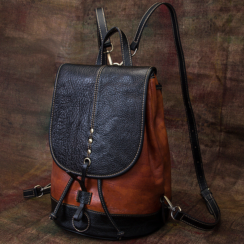 Stylish dual-tone leather backpack with chic hardware details, ideal for college or everyday use.