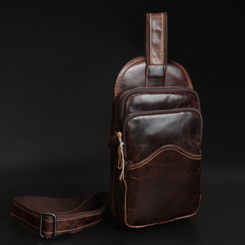 Elegant brown leather men's casual chest bag with retro design, featuring multiple pockets and adjustable strap for versatile styling.