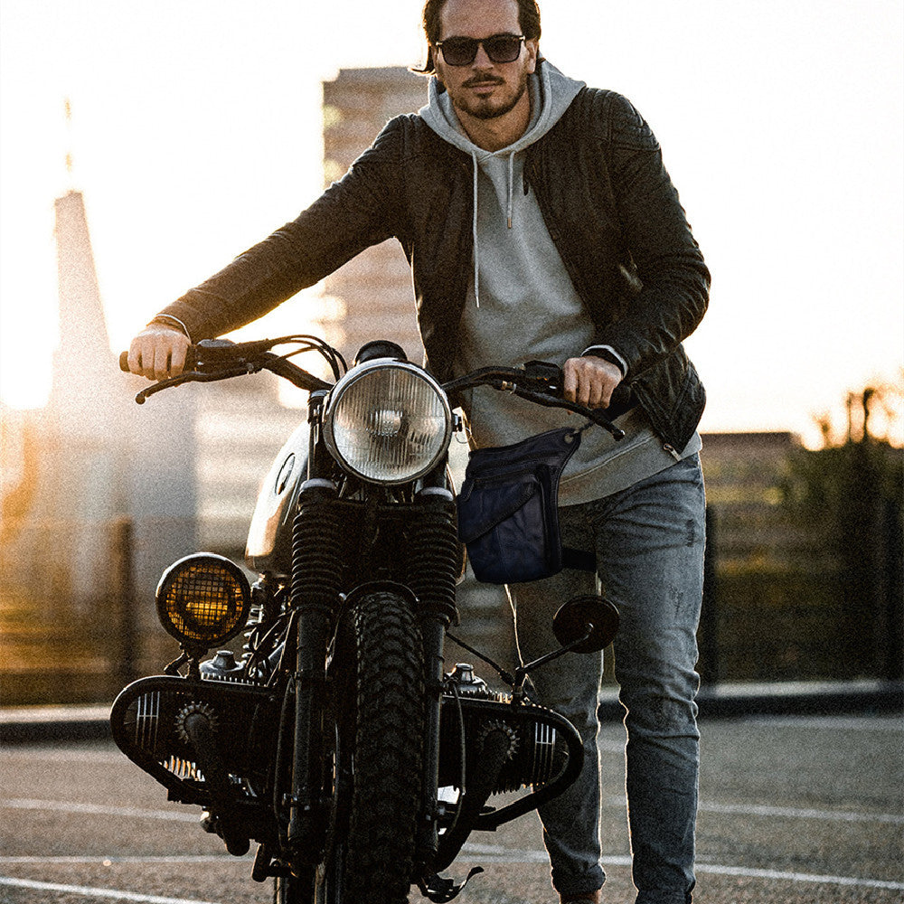 Stylish man riding classic motorcycle on city street