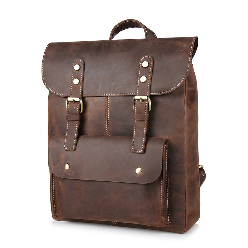 Vintage-style leather backpack with dual buckle flap closure, front pockets, and rugged, distressed brown leather construction.