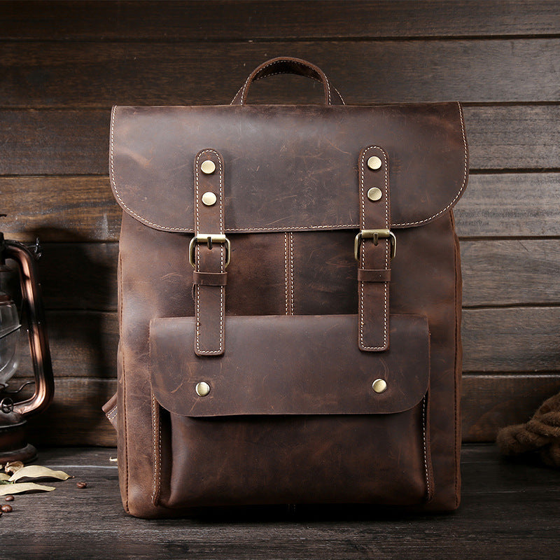 Durable dark brown leather backpack with buckled straps, vintage style, suitable for travel or everyday use