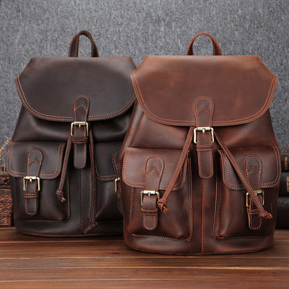 Two leather backpacks from the brand Bags, Shoes & More displayed on a wooden surface. The backpacks feature a classic, sophisticated design with a brown leather exterior, antique-style buckles, and a roomy interior for travel and leisure.