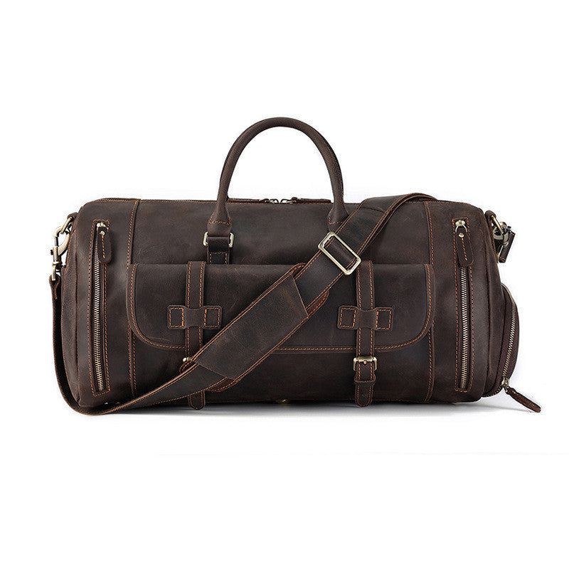 Rugged brown leather travel bag with multiple zippered compartments, a detachable shoulder strap, and a large central compartment for ample storage capacity, designed for both style and functionality.