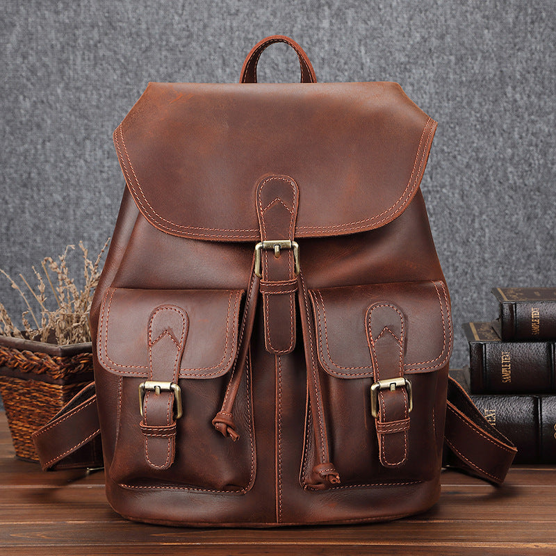 Handsome leather backpack with a spacious design and multiple pockets for storage. The rich brown tone and brass hardware create a sleek, sophisticated look. This high-quality bag is perfect for travel, work, or everyday use.